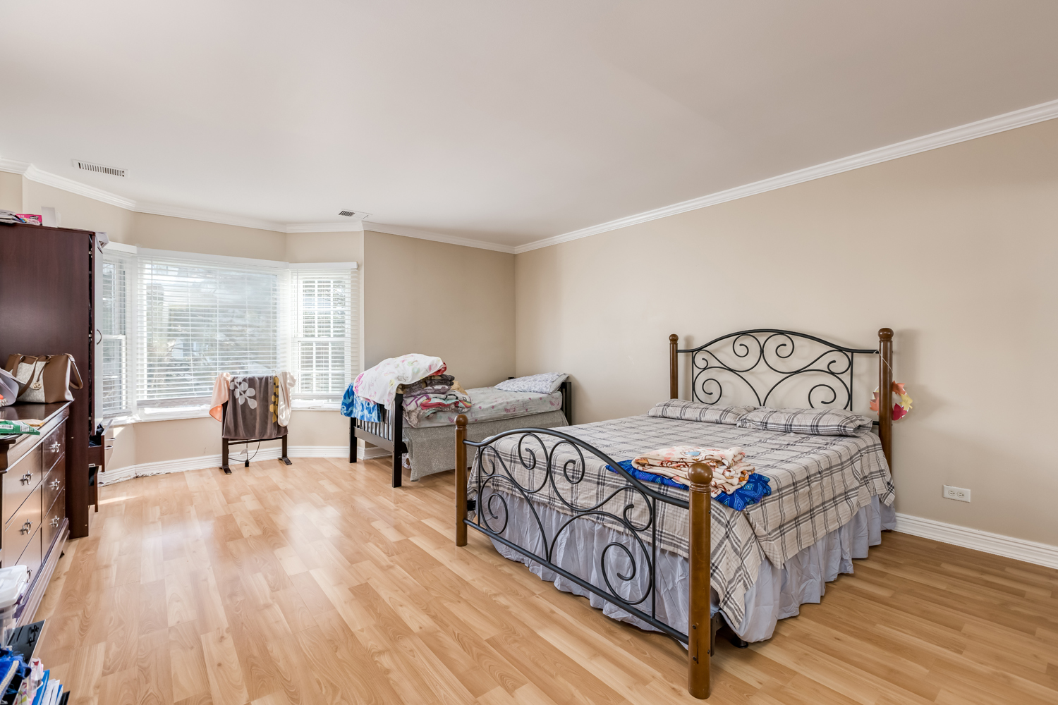 8630 Waukegan Road, Unit 317 Morton Grove, IL 60053 - Photo 11 of 15 a bedroom with a bed and a flat tv screen on dresser