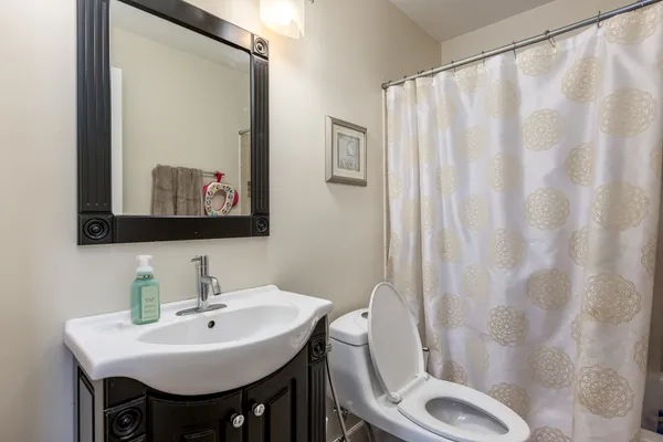 a bathroom with a sink toilet and mirror