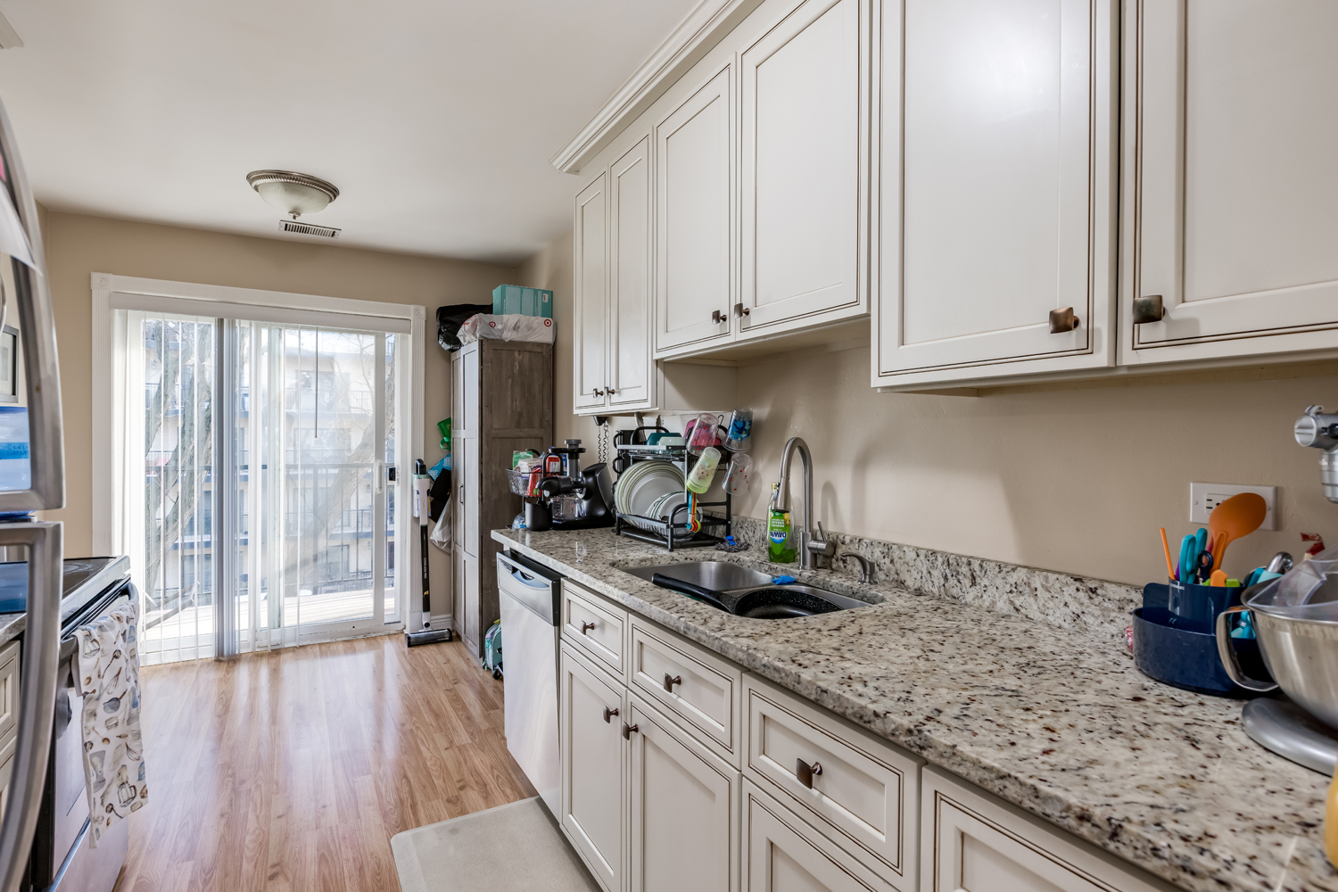 8630 Waukegan Road, Unit 317 Morton Grove, IL 60053 - Photo 6 of 15 a kitchen with granite countertop a sink stainless steel appliances and cabinets
