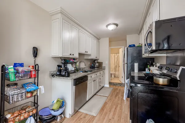 a kitchen with refrigerator a stove a sink and a refrigerator