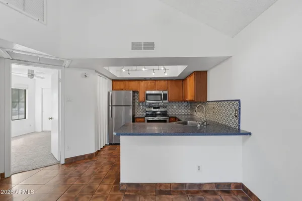 a kitchen with stainless steel appliances granite countertop a sink and a refrigerator