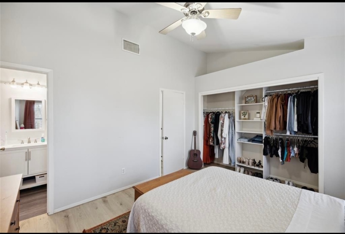 11404 Walnut Ridge Drive, Unit 10 Austin, TX 78753 - Photo 7 of 12 a bedroom with a bed and a chandelier