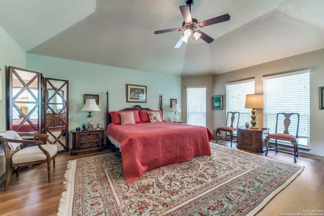 a bedroom with a large bed and a chandelier