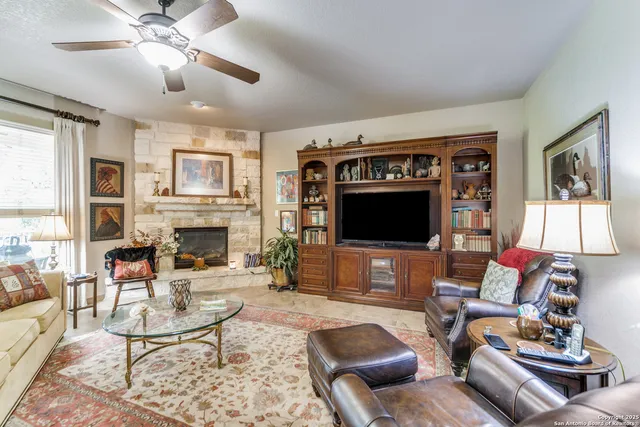 a living room with furniture a fireplace and a large window
