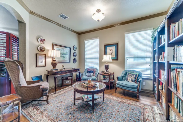 a kitchen with granite countertop a table chairs microwave and refrigerator