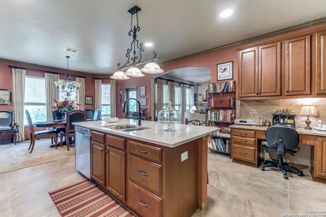 a kitchen with stainless steel appliances granite countertop a stove a sink dishwasher a dining table and chairs with wooden floor