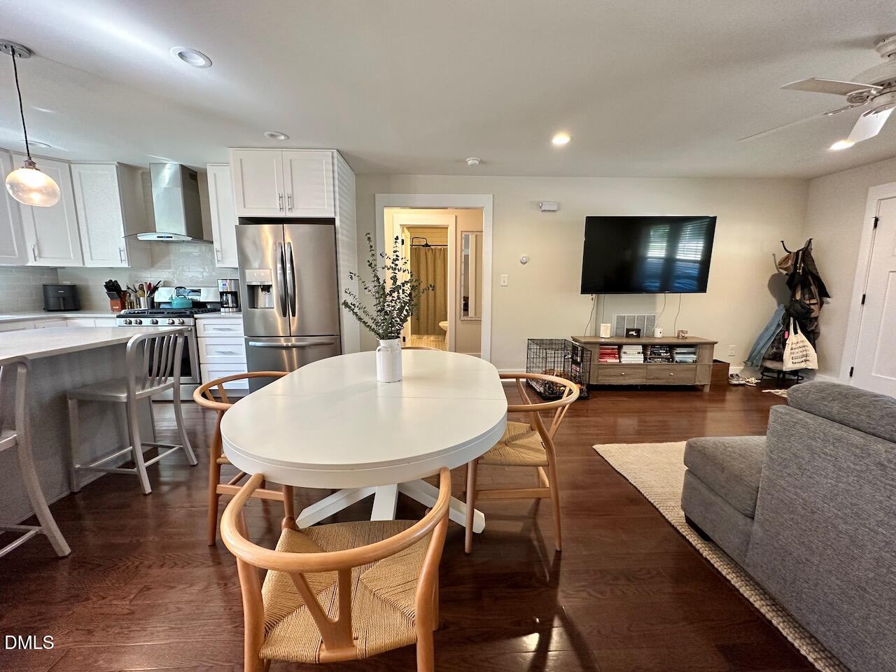 1006 East Martin Street Raleigh, NC 27601 - Photo 6 of 22 a living room with stainless steel appliances furniture a dining table and a flat screen tv
