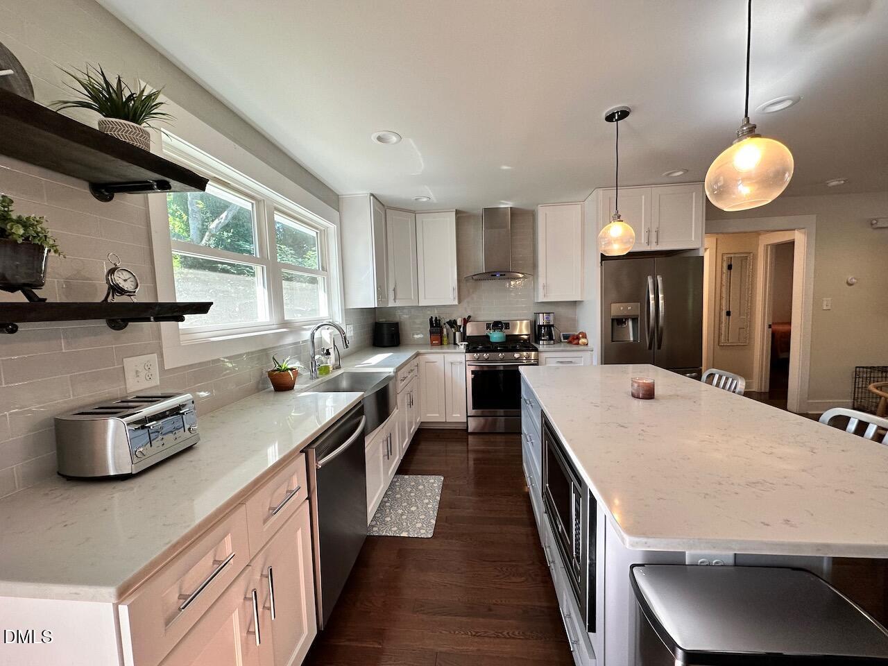 1006 East Martin Street Raleigh, NC 27601 - Photo 9 of 22 a kitchen with kitchen island granite countertop a stove a sink and a refrigerator