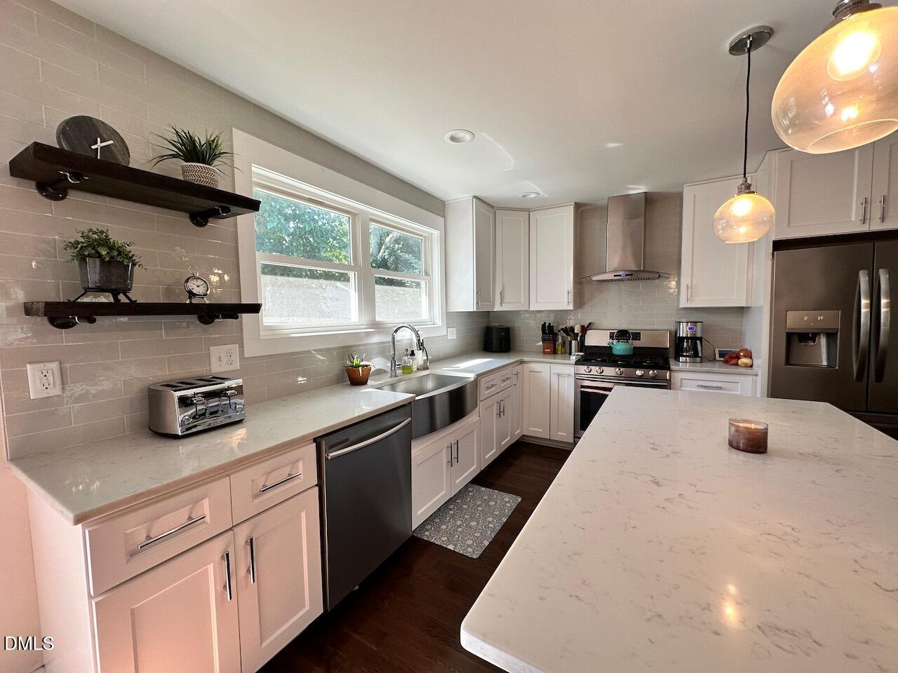 1006 East Martin Street Raleigh, NC 27601 - Photo 10 of 22 a kitchen with kitchen island granite countertop a sink a stove and a refrigerator