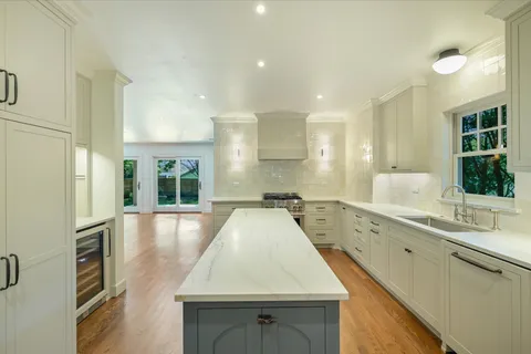 a large kitchen with kitchen island a large counter top space and stainless steel appliances