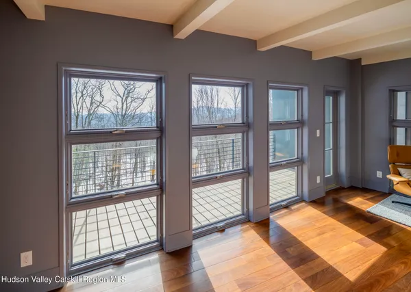 a bedroom with a bed a large window and sitting space