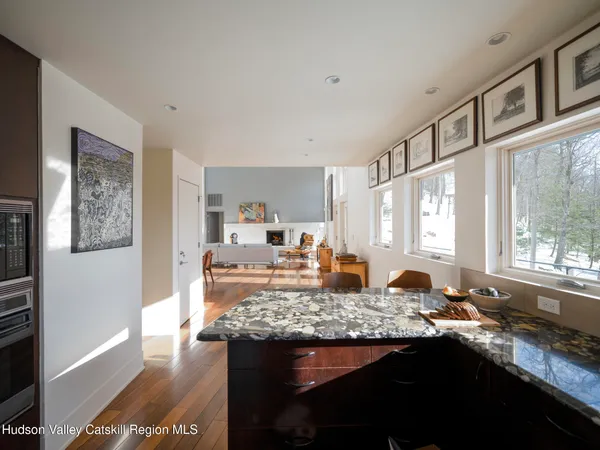 a living room with furniture and a dining table with wooden floor