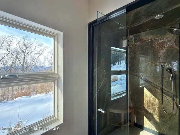 a view of a backyard with chairs and potted plants