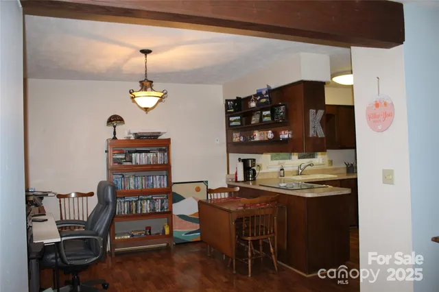 a kitchen with a refrigerator and chairs