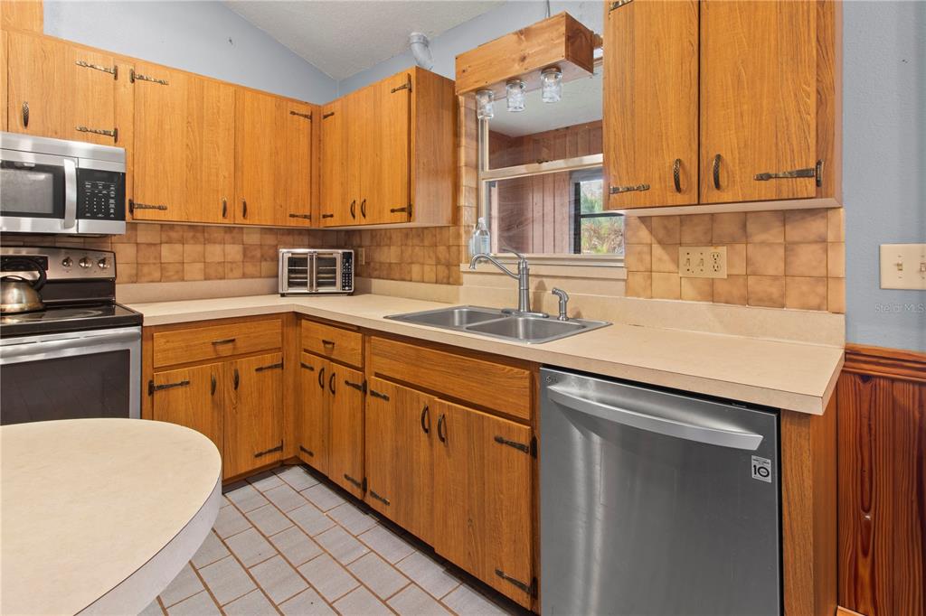 1143 Meyers Road Venice, FL 34292 - Photo 11 of 59 a kitchen with stainless steel appliances granite countertop a sink a stove and cabinets