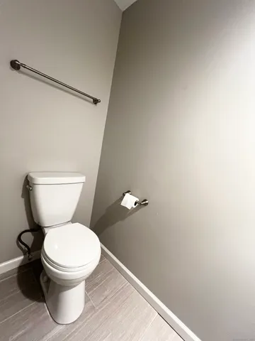 a white toilet sitting next to a shower