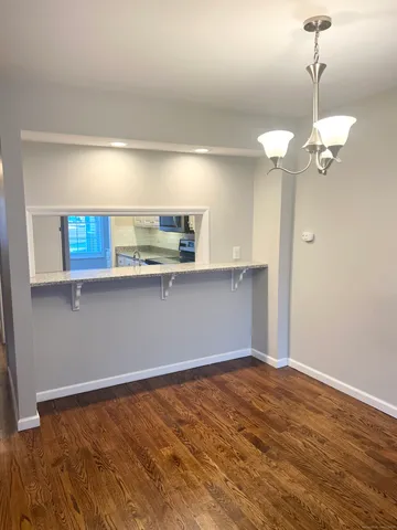 a view of a kitchen with a sink dishwasher a stove top oven with wooden floor