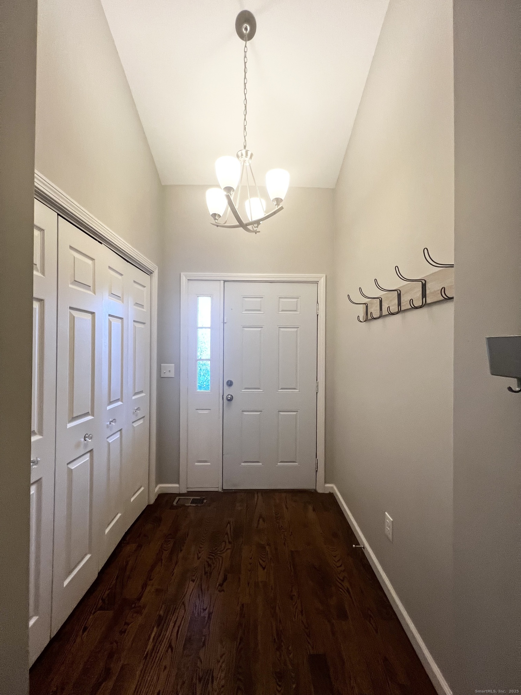 751 Long Hill Road, Unit D Middletown, CT 06457 - Photo 10 of 28 a view of a hallway with wooden floor and a chandelier