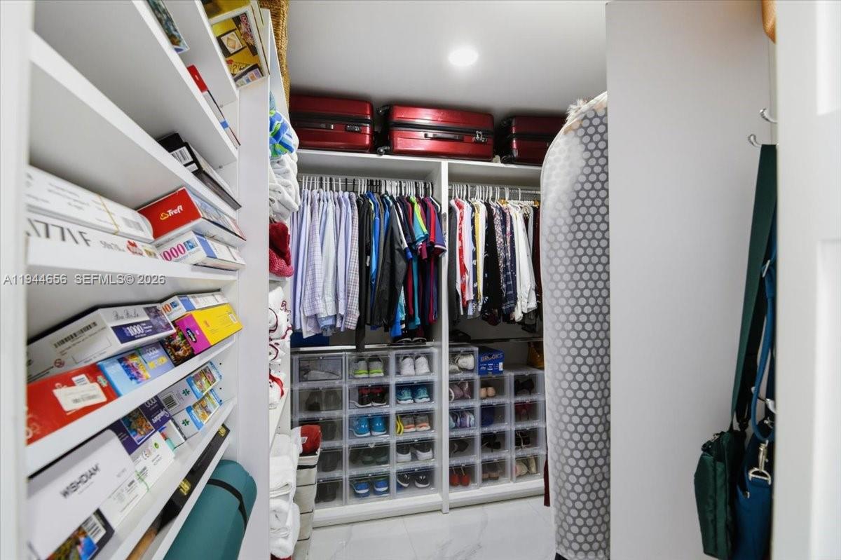 8925 Collins Avenue, Unit 9F Surfside, FL 33154 - Photo 19 of 73 a view of walk in closet with clothes and shoes