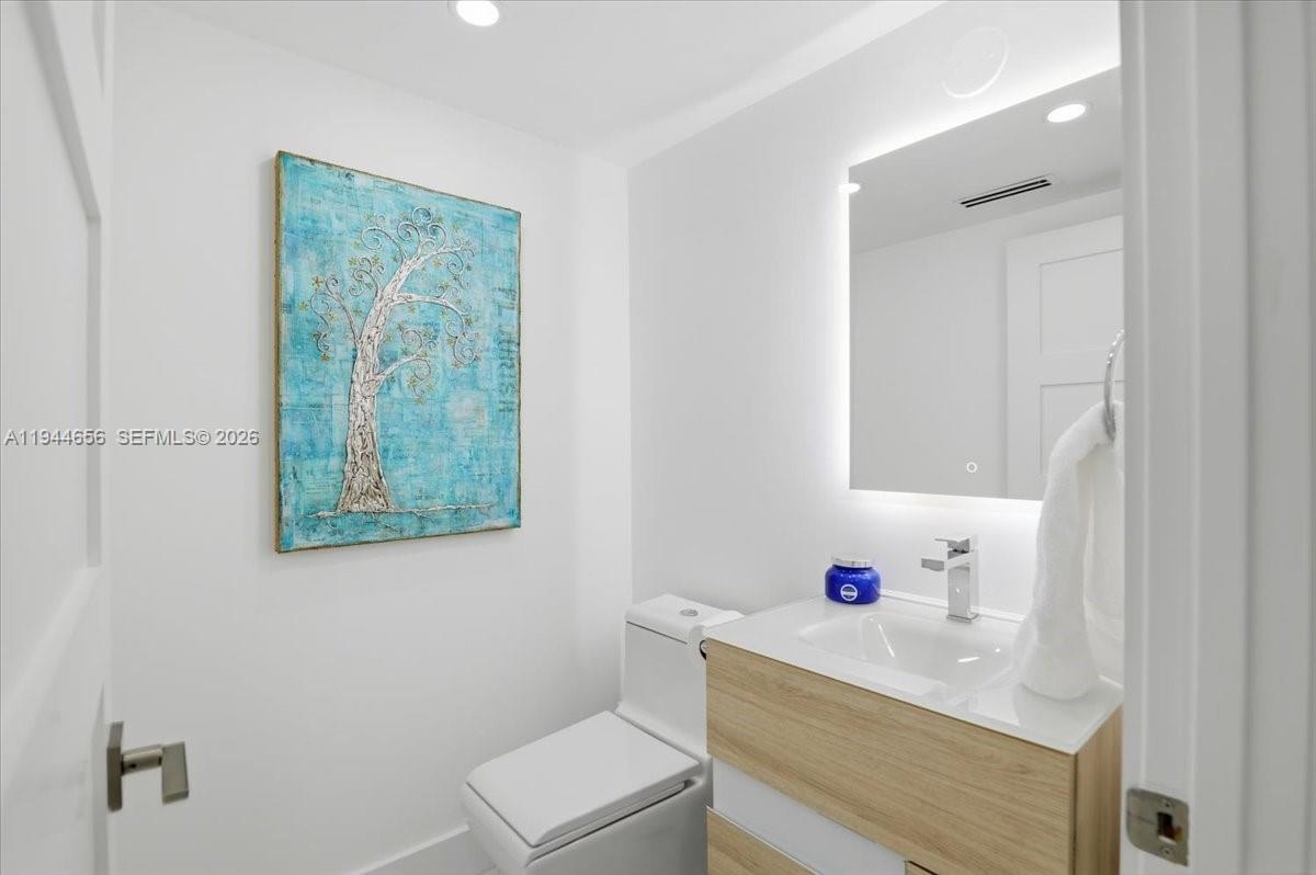 8925 Collins Avenue, Unit 9F Surfside, FL 33154 - Photo 28 of 73 a bathroom with a sink vanity mirror and toilet
