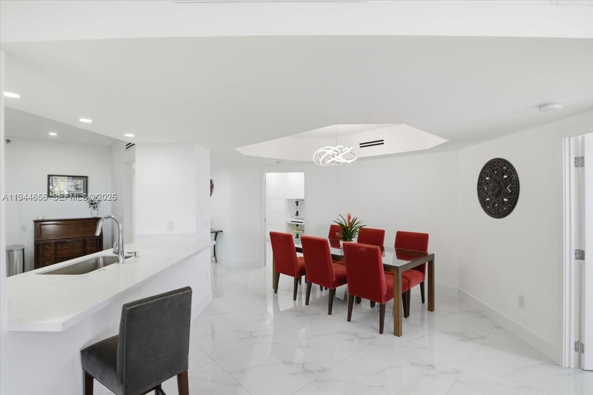 8925 Collins Avenue, Unit 9F Surfside, FL 33154 - Photo 32 of 73 a view of a dining room with furniture and chandelier