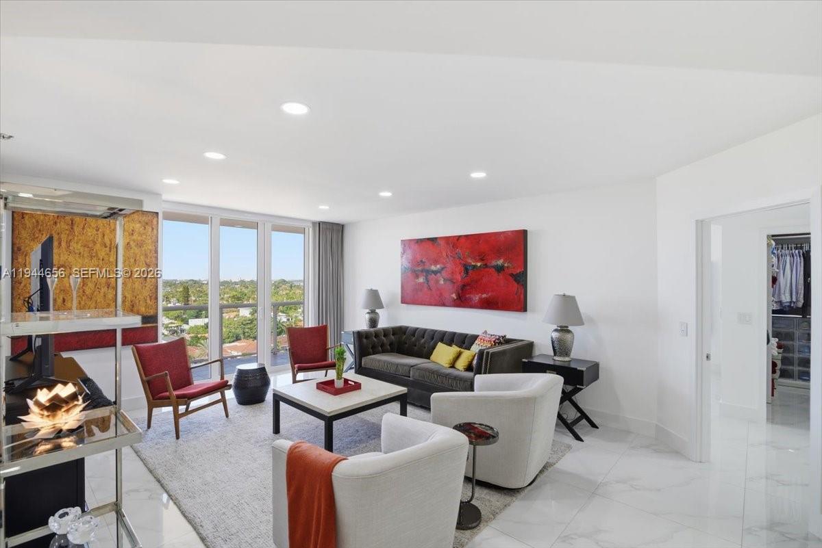 8925 Collins Avenue, Unit 9F Surfside, FL 33154 - Photo 35 of 73 a living room with furniture a floor to ceiling window and a flat screen tv