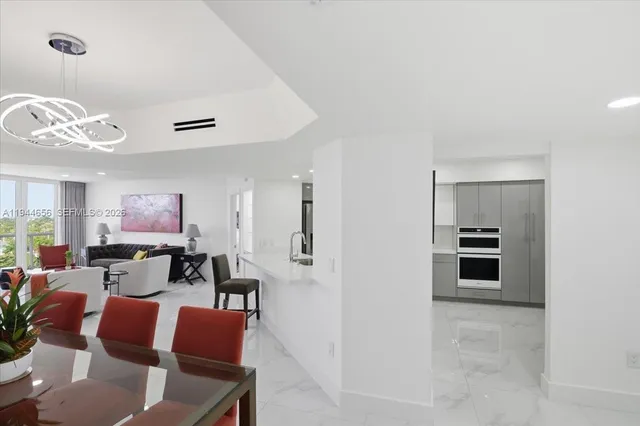 a view of a dining room with furniture and a chandelier fan