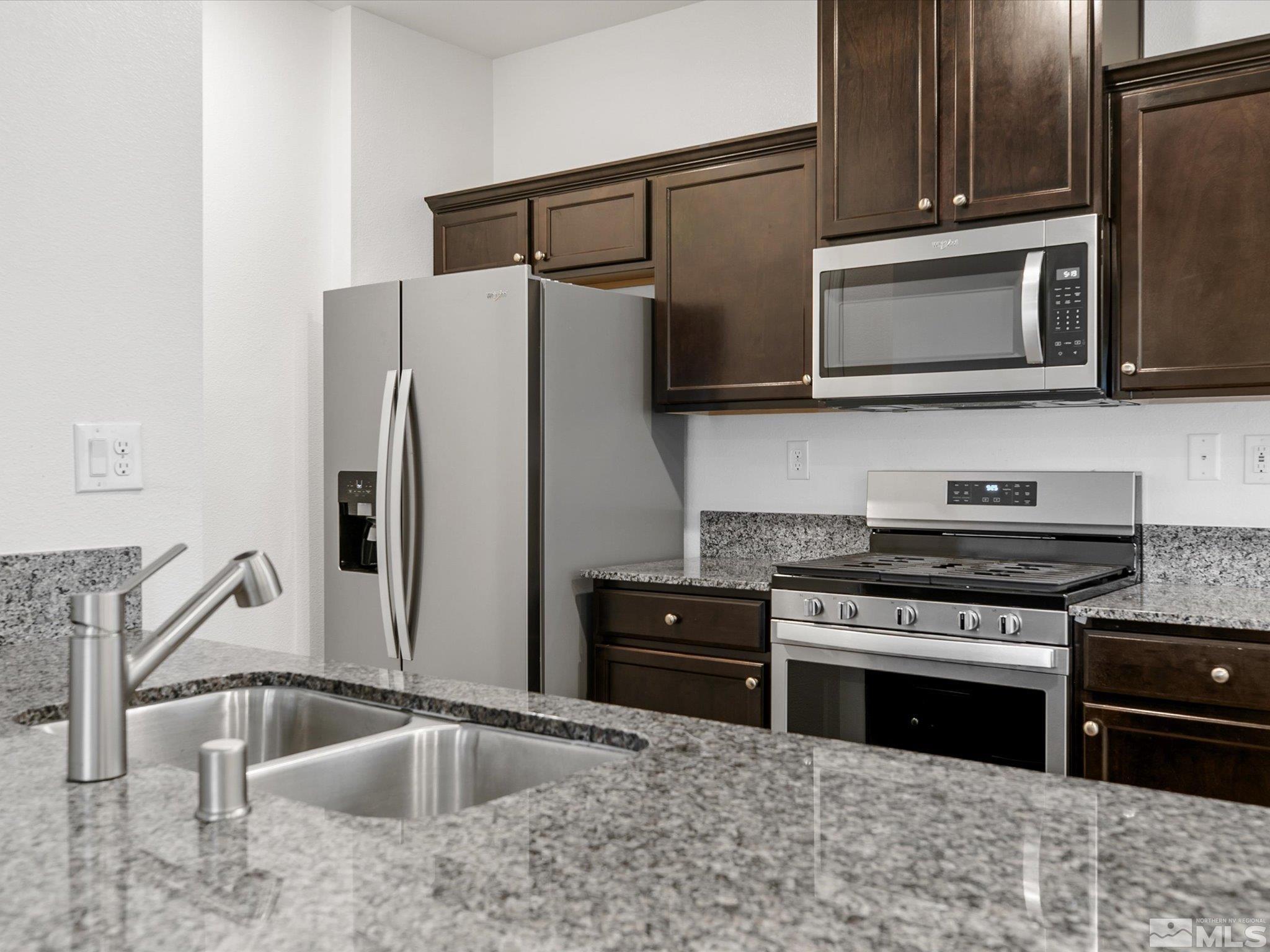 405 Autumn Breeze Circle Reno, NV 89511 - Photo 11 of 28 a kitchen with stainless steel appliances granite countertop a sink stove and microwave