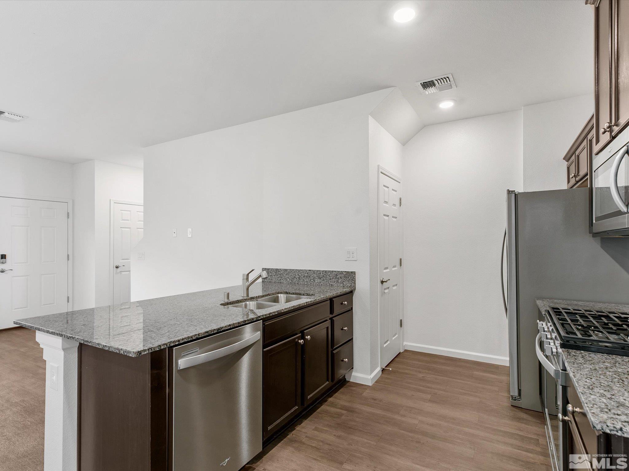 405 Autumn Breeze Circle Reno, NV 89511 - Photo 12 of 28 a kitchen with granite countertop a stove and a refrigerator