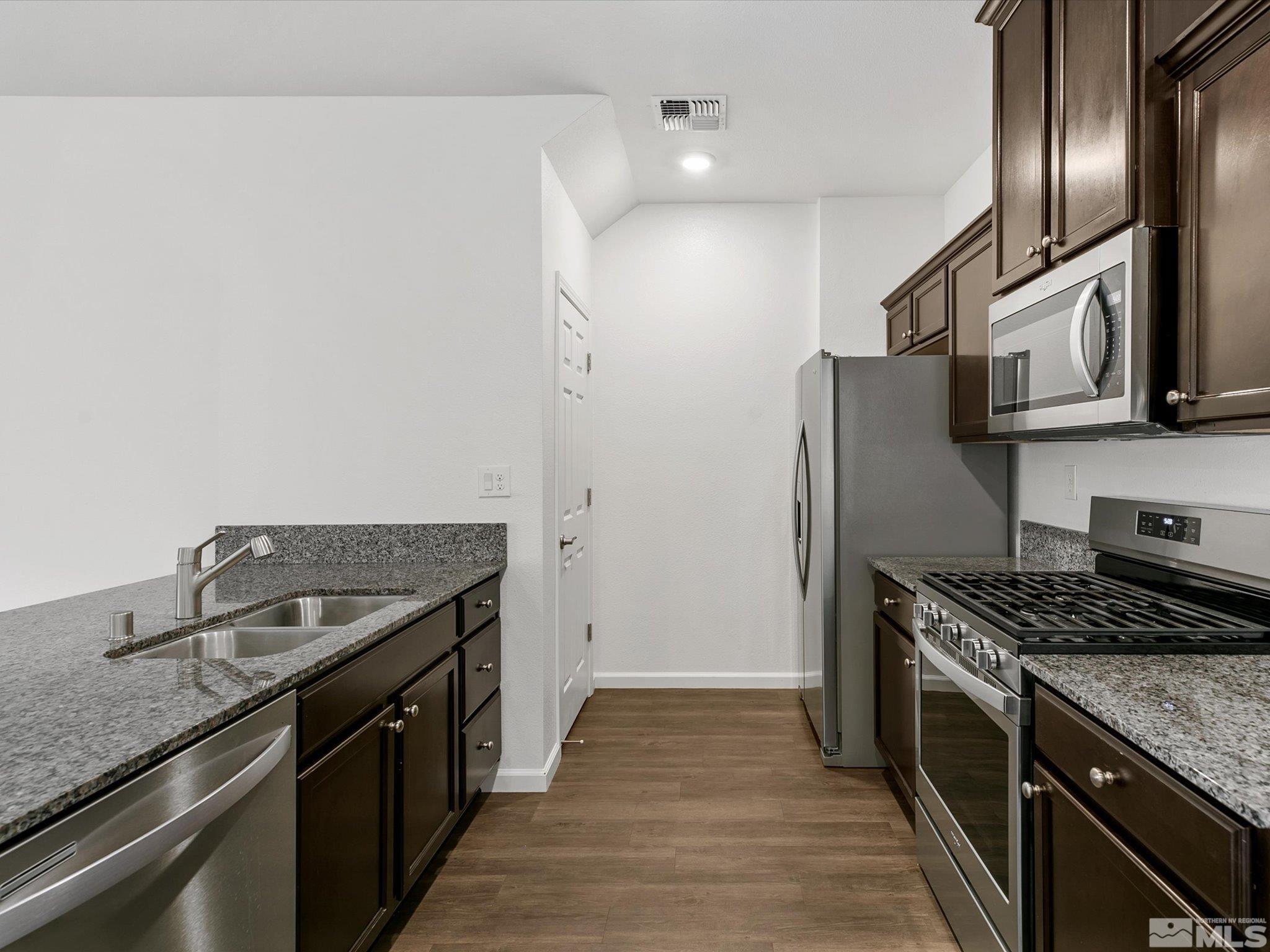405 Autumn Breeze Circle Reno, NV 89511 - Photo 13 of 28 a kitchen with stainless steel appliances granite countertop a stove top oven a sink and dishwasher