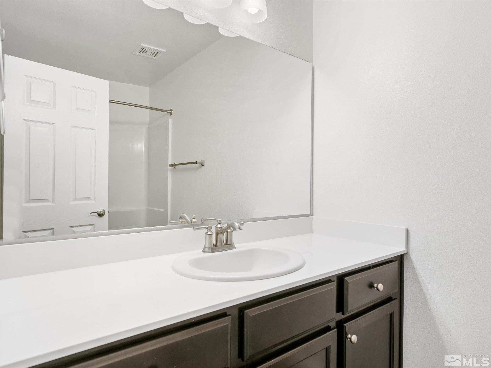 405 Autumn Breeze Circle Reno, NV 89511 - Photo 25 of 28 a bathroom with a sink and a mirror