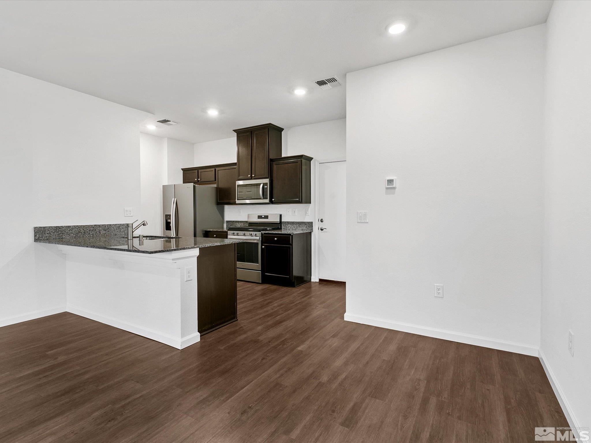 405 Autumn Breeze Circle Reno, NV 89511 - Photo 8 of 28 a kitchen with wooden floor and stainless steel appliances