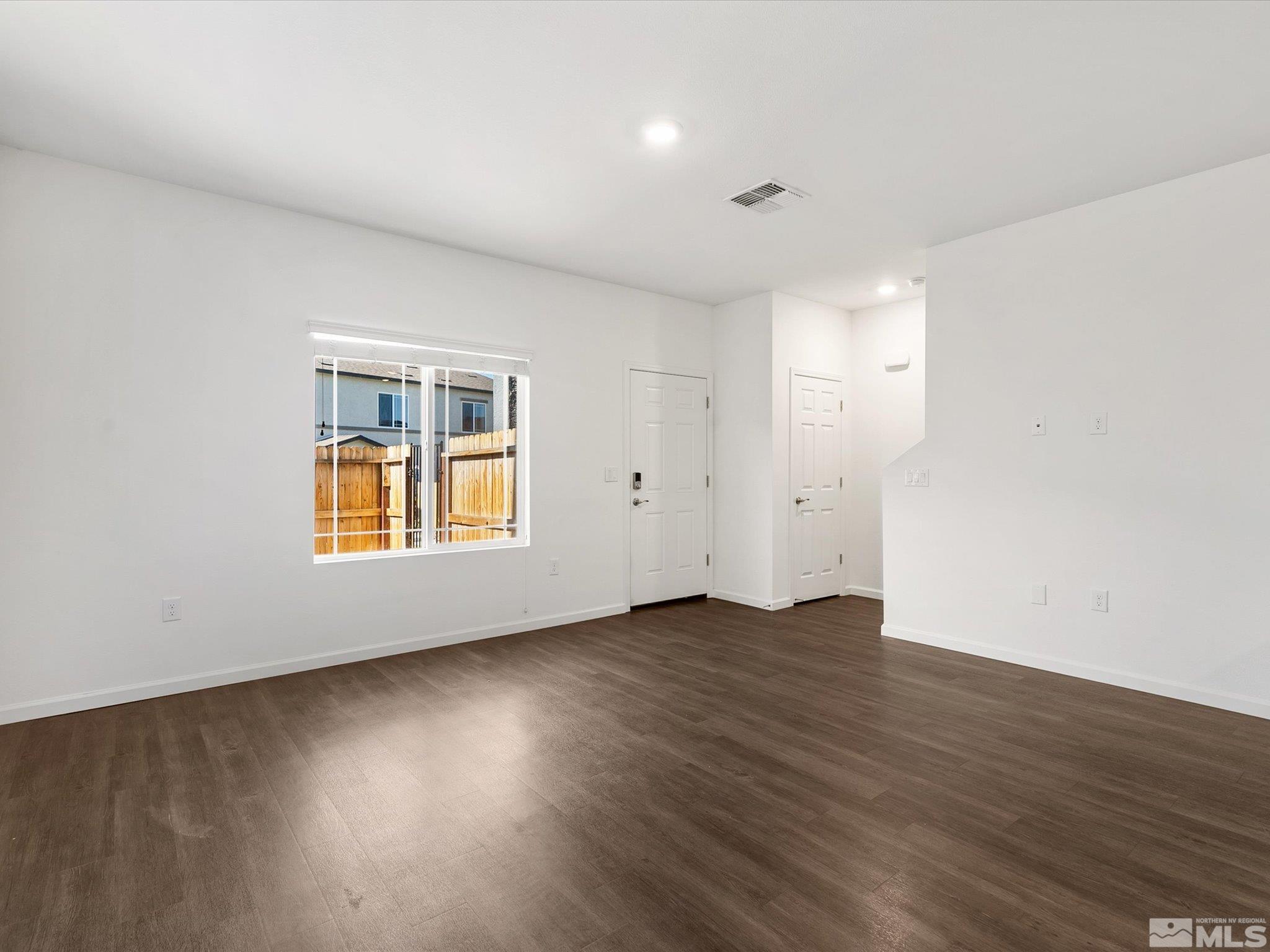 405 Autumn Breeze Circle Reno, NV 89511 - Photo 9 of 28 an empty room with wooden floor and windows