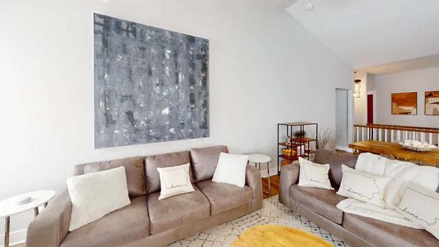 a living room with stainless steel appliances kitchen island granite countertop furniture wooden floor and a kitchen view