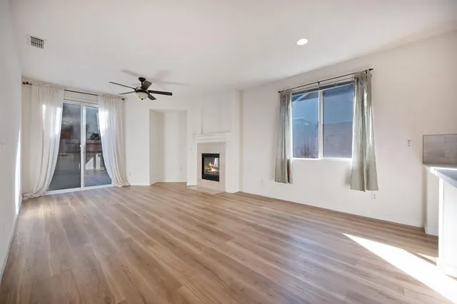 a view of empty room with wooden floor and ceiling fan