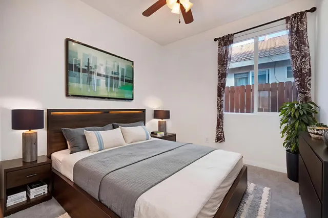 an empty room with a window and a ceiling fan