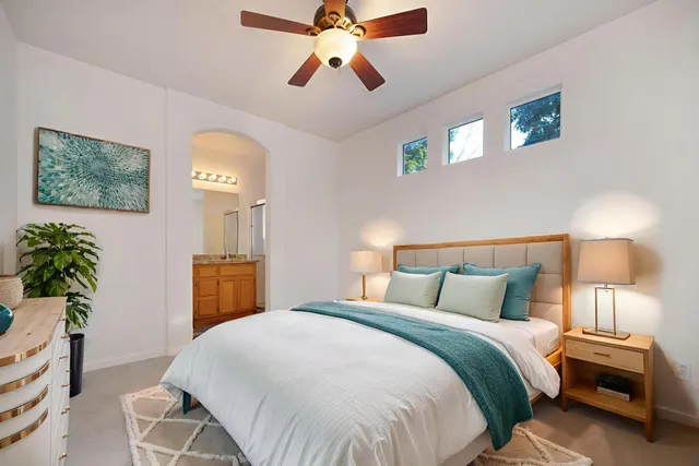 an empty room with windows and fan