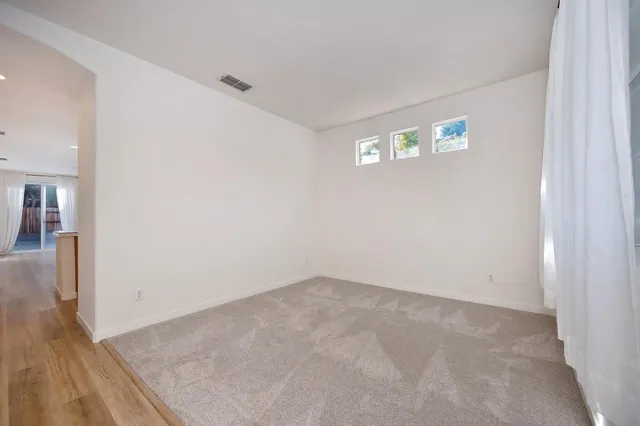a view of an empty room with window and closet area