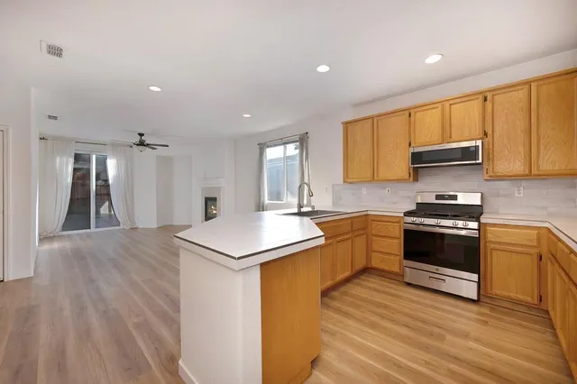 a kitchen with stainless steel appliances granite countertop a stove a sink and a refrigerator