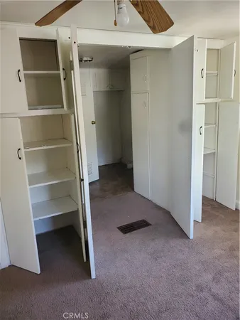 en empty room with windows and fan