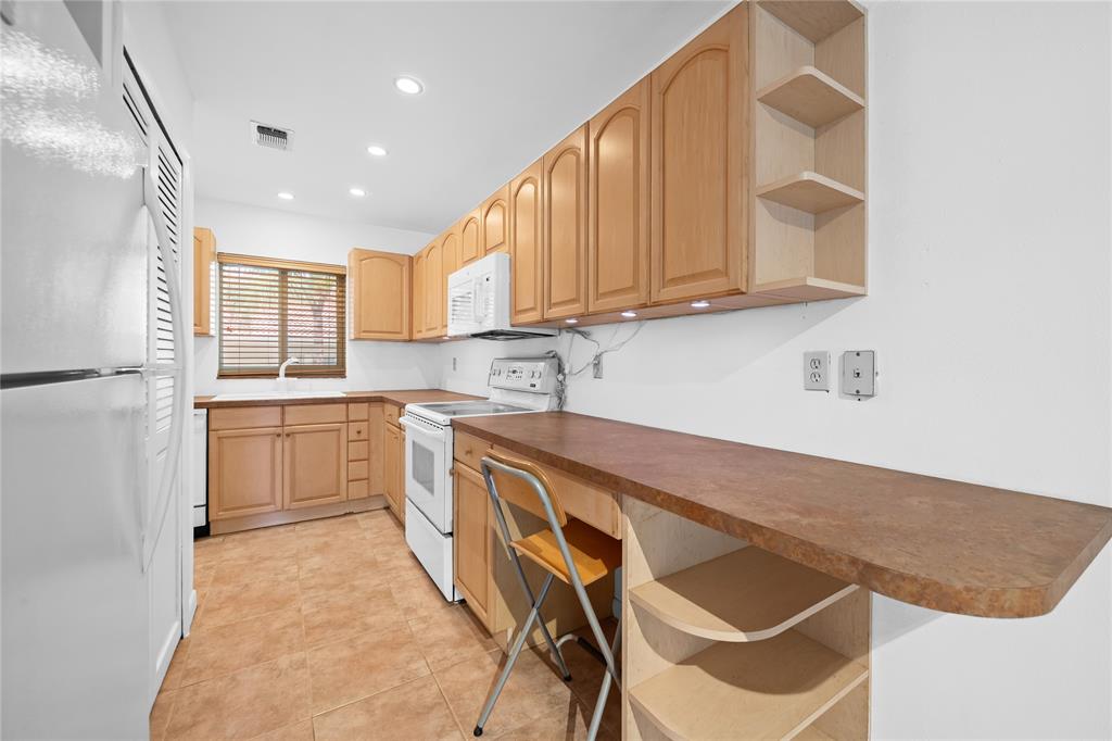 2501 South Ocean Boulevard, Unit 301 Boca Raton, FL 33432 - Photo 12 of 32 a kitchen with granite countertop white cabinets and white appliances