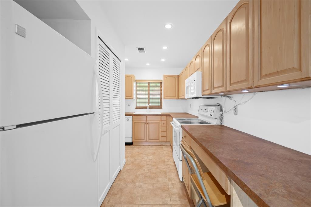 2501 South Ocean Boulevard, Unit 301 Boca Raton, FL 33432 - Photo 6 of 32 a kitchen with a refrigerator sink stove and cabinets