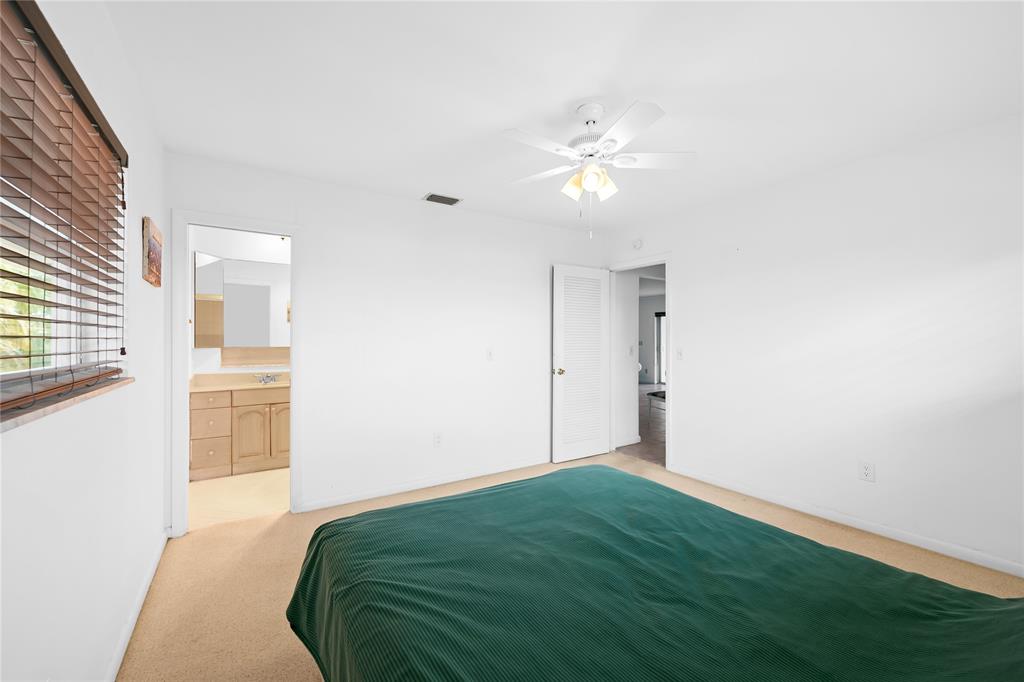 2501 South Ocean Boulevard, Unit 301 Boca Raton, FL 33432 - Photo 9 of 32 a bedroom with a bed and cabinets