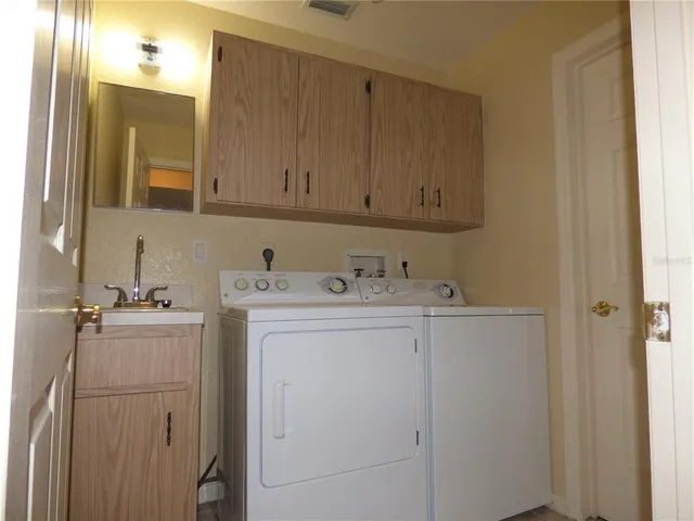 a utility room with cabinets washer and dryer