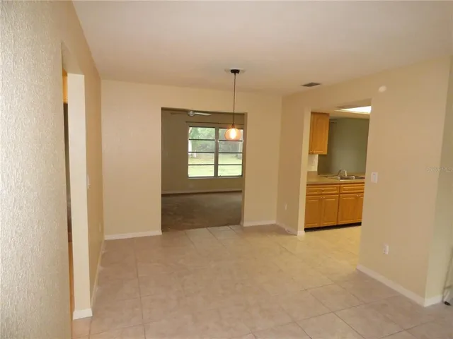 an empty room with windows and cabinet