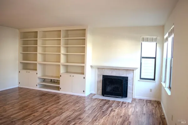 a view of an empty room with a fireplace and a window