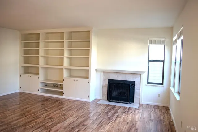 a view of an empty room with a fireplace and a window
