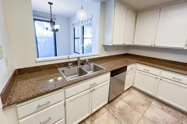 a kitchen with granite countertop white cabinets and white appliances