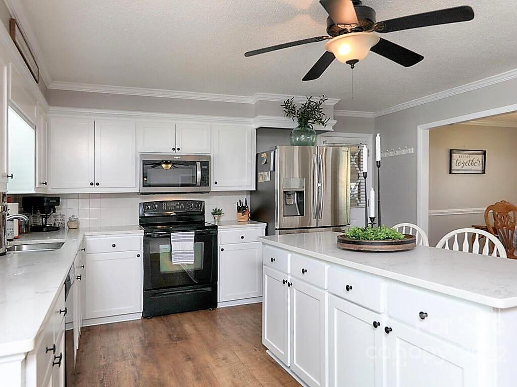 5600 Wright Road Kannapolis, NC 28081 - Photo 15 of 45 a kitchen with kitchen island granite countertop stainless steel appliances a stove sink microwave and cabinets