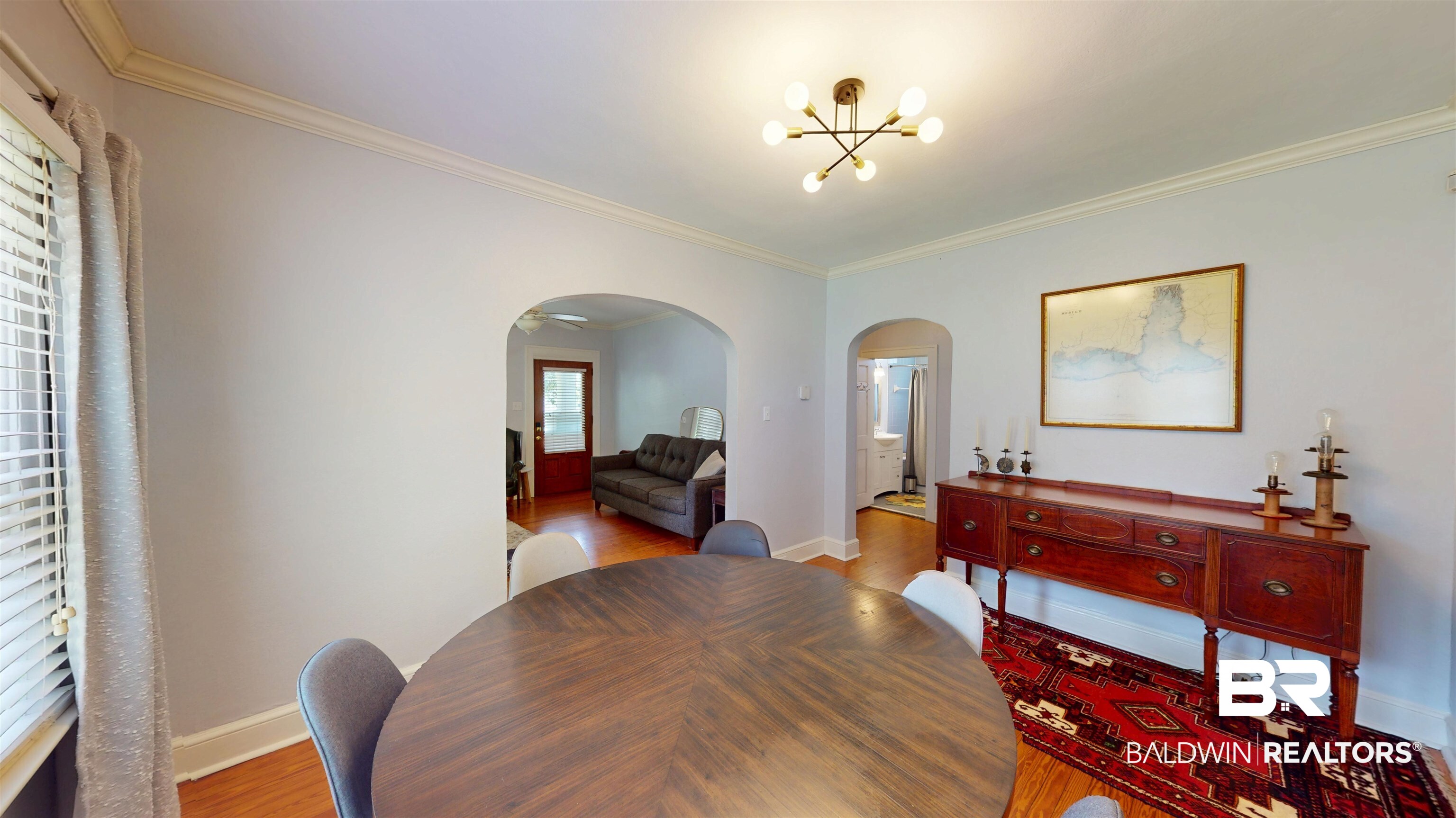 266 Westwood Street Mobile, AL 36606 - Photo 11 of 34 Dining space featuring arched walkways, a chandelier, crown molding, baseboards, and wood finished floors